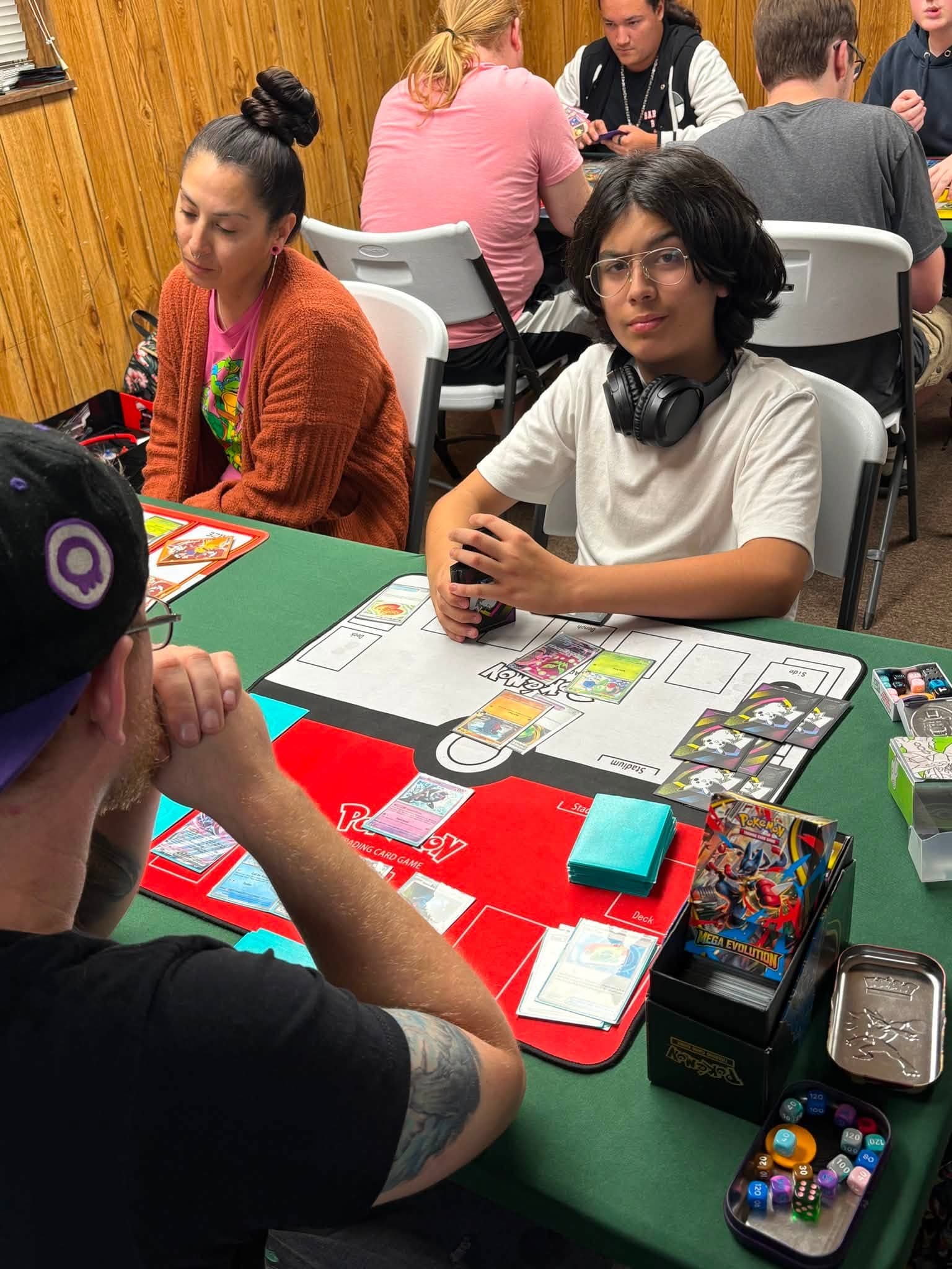 Players sharing a Pokémon game at a shop table