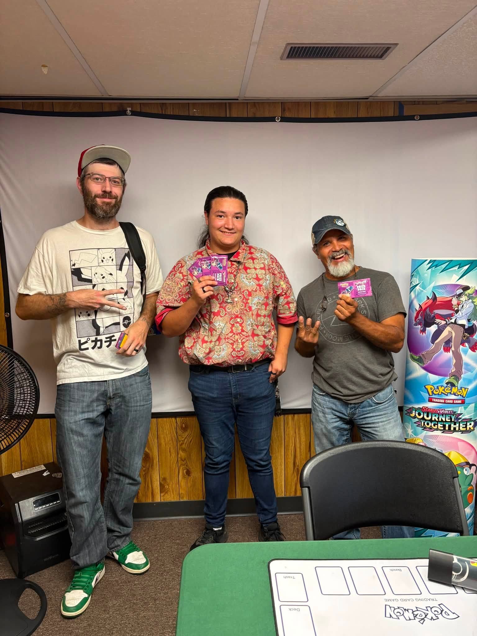 Three local players posing with cards at Masterwork Gaming